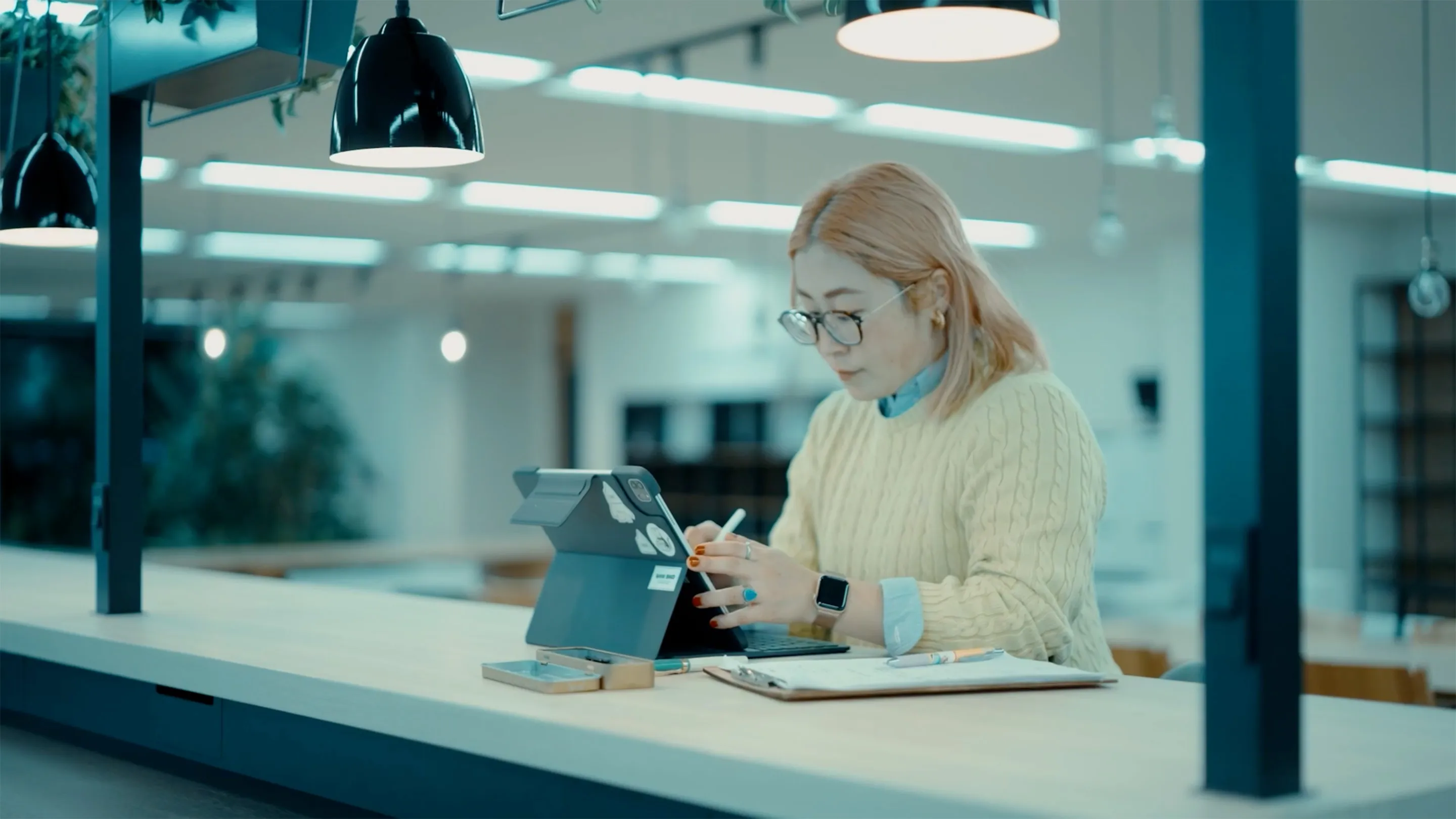 自治体で働く女性デザイナーがタブレットで作業している様子